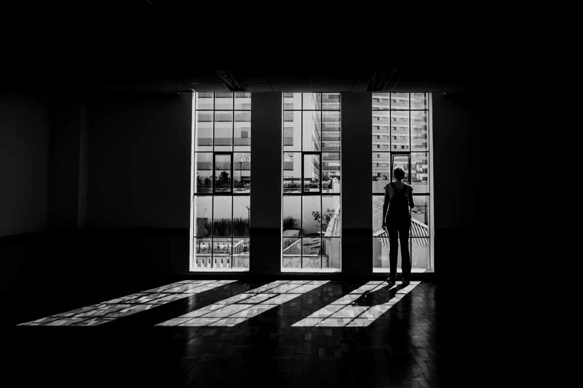 silhouette of person standing facing window